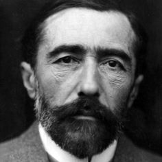 an old black and white photo of a man with a beard wearing a suit jacket