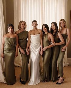 the bridesmaids are posing for a photo in their green and gold gowns