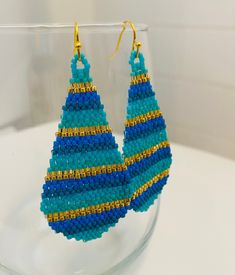 Beautiful and bright multicolor turquoise, blue and gold glass Miyuki seed bead earrings are woven in a stripe pattern with and finished with a gold ear wire and accents. Classic and flattering. I'm always happy to customize if you have something specific in mind. All items are handmade by yours truly and come from a smoke free home. Thanks for looking! Turquoise Teardrop Beaded Earrings As Gift, Turquoise Teardrop Beaded Earrings For Gifts, Colorful Beads Long Drop Jewelry As Gift, Multicolor Drop Earrings With Spacer Beads, Colorful Beads Long Drop Jewelry For Gift, Long Drop Colorful Beads Jewelry Gift, Colorful Beads Teardrop Jewelry For Crafting, Colorful Beads Long Drop Jewelry Gift, Multicolor Teardrop Jewelry With Spacer Beads