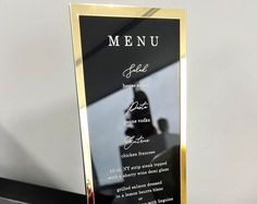 a black and gold plate with a menu on it