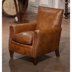 a brown leather chair sitting on top of a hard wood floor