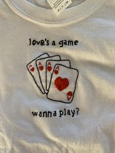 a white t - shirt with four playing cards on it that says, jove's a game wanna play?