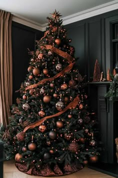 a christmas tree is decorated with gold and silver balls, ribbons and ornaments on it