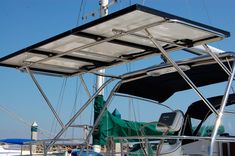 the front end of a boat with its sunroofer open and water in the background