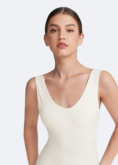 Sculpt and smooth with our Waist-Contouring Bodysuit. Designed to enhance your natural shape, this bodysuit provides gentle compression for a flattering fit in standard and plus size options. Whether layered or worn on its own, it’s the perfect mix of style and support. Solid Color Second-skin Lined Top, Spring Second-skin Smoothing Bodysuit, Summer Compressive Smoothing Shapewear, Summer Solid Color Elastane Shapewear, Fitted Bodysuit With Smooth Texture, Seamless Scoop Neck Shapewear For Summer, Spring Shapewear Bodysuit With Lined Body, Solid Seamless Leotard For Loungewear, Fitted V-neck Shapewear For Summer