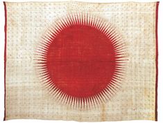 an old red and white cloth with a circular design on the center, in front of a