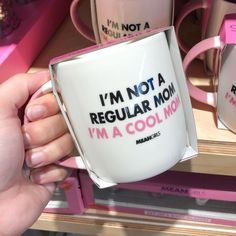 a person holding a coffee mug that says i'm not a regular mom, i'm a cool mom