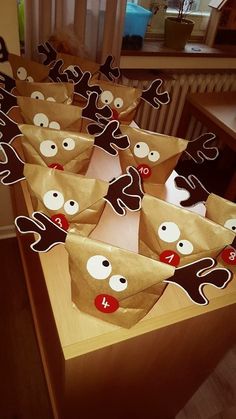 brown paper bags with reindeer faces and numbers on them are lined up in a row