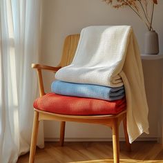 a stack of blankets sitting on top of a wooden chair