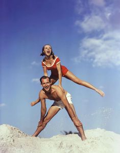 a man and woman are playing in the sand