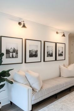 a living room with pictures hanging on the wall and a couch in front of it