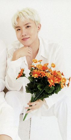 the man is holding flowers in his hand