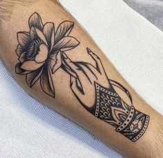 a black and white photo of a person's arm with a flower on it