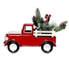 a red truck with a christmas tree in it's flat bed and pine cones on the back