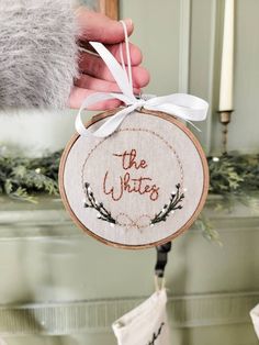 a hand holding a cross stitch ornament with the words, the whits on it