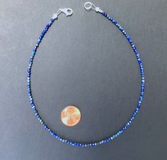 A minimalist necklace made with rich blue beads of genuine lapis lazuli. These AAA quality stones measure 2mm in diameter, and they are round with multifaceted cuts that give them a little extra shimmer in the light. There is a small silver bead at each end, and this connects with a sterling silver lobster claw clasp in the back. Available in a variety of lengths, and comes packaged in a small gift box for you. Ships in 1 business day, via USPS ground advantage. Lapis Lazuli Necklace With Faceted Beads, Round Lapis Lazuli Necklace With Faceted Beads, Faceted Sapphire Lapis Lazuli Necklace, Blue Lapis Lazuli Crystal Necklaces With Faceted Beads, Blue Faceted Lapis Lazuli Beaded Necklaces, Blue Lapis Lazuli Crystal Necklace With Faceted Beads, Faceted Sapphire Round Bead Necklaces, Blue Faceted Lapis Lazuli Beaded Necklace, Sapphire Necklaces With Faceted Round Beads