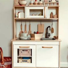 a kitchen with white cabinets and wooden shelves