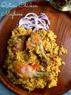 a wooden plate topped with rice and meat