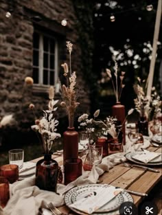 the table is set with plates and vases