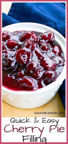 a white bowl filled with cherries sitting on top of a wooden table