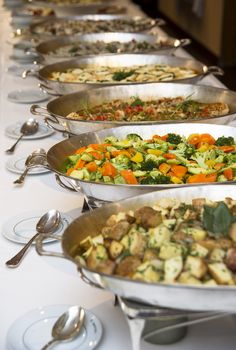 a buffet line with many different types of food on plates and serving utensils