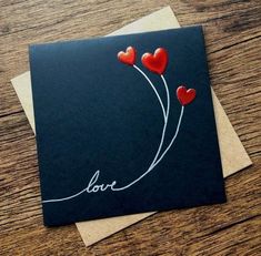 two red hearts are attached to a black card with the word love written on it