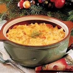 a green casserole dish filled with macaroni and cheese on a table