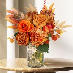 a vase filled with orange flowers on top of a wooden table