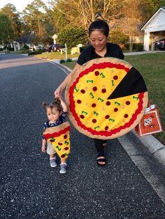 a woman and her daughter are walking down the street with a large pizza costume on