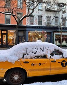 a taxi cab covered in snow on a city street