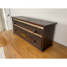 an old wooden dresser with drawers on it's side in a room that has hardwood floors and white walls