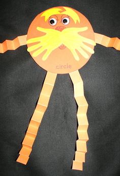 an orange paper plate with a face and arms made to look like a human body