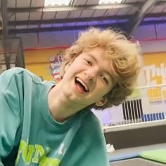 a young boy is laughing while standing on a trampoline track in a gym