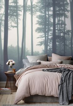 a bedroom with a large wall mural in the background and a bed covered in pink linens