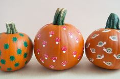 three painted pumpkins sitting next to each other