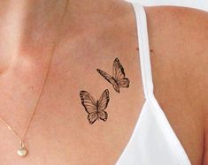 two butterflies on the back of a woman's shoulder