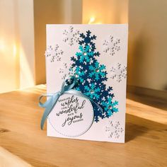 a handmade christmas card with a blue tree on it