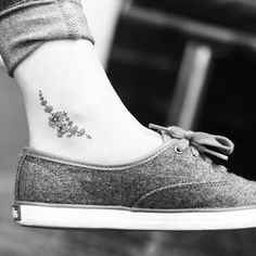 a woman's foot with a small flower tattoo on her left side ribcage