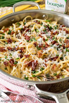 pasta with bacon and parmesan cheese in a silver pan on a red checkered cloth