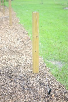 a wooden pole is in the middle of some mulch