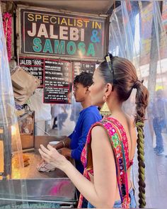 two women standing in front of a food cart