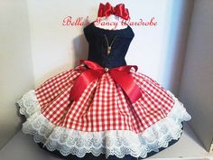 a red and white checkered dress is on display in a box with the name bella's fancy bakehouse