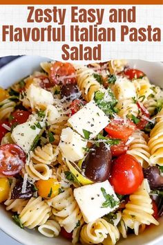 a white bowl filled with pasta salad and topped with fettuccine, tomatoes, olives, parmesan cheese