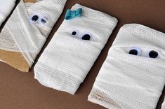 three wrapped up bags with eyes on them