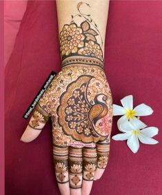 a woman's hand decorated with henna and flowers