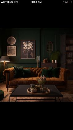 an image of a living room setting with dark green walls and leather couches in the middle