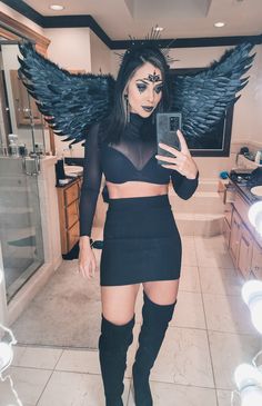 a woman with wings on her head is taking a selfie in the mirror while holding a cell phone