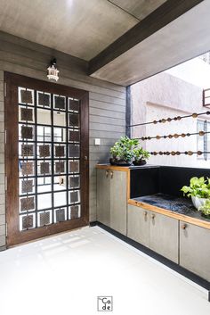 a room with some plants on the counter and a door in the wall behind it