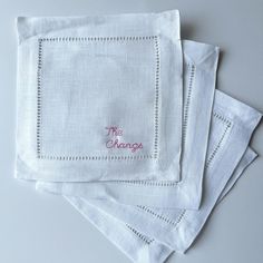 three napkins with embroidered words on them