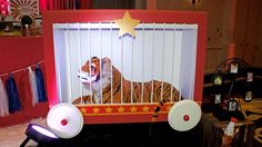 a tiger in a cage on display at a children's birthday party with lights and decorations